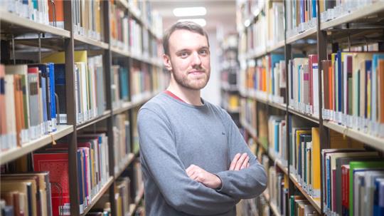 André Graën steht in der Bibliothek der Carl von Ossietzky Universität in Oldenburg. Graën belegt den neuen Studiengang Niederdeutsch, der für den Unterricht an weiterführenden Schulen ausbilden soll.