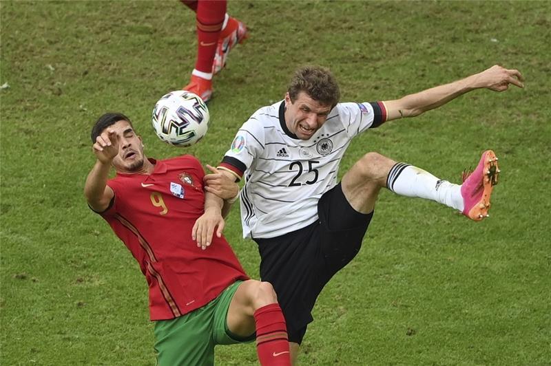 Andre Silva (l) und Deutschlands Thomas Müller kämpfen um den Ball. Foto: Matthias Hangst/Pool Getty/dpa