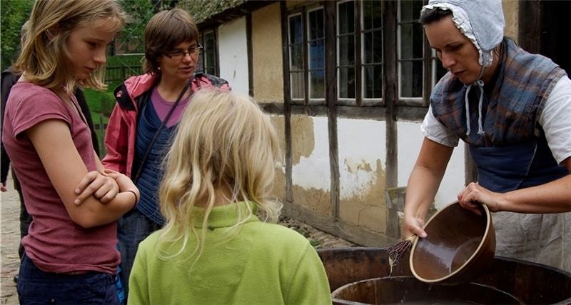 Andrea Rohe lässt sich mit ihren Töchtern Klara (10) und Eva (7) von Katharina Schulz traditionelle Arbeitsweisen vorführen.