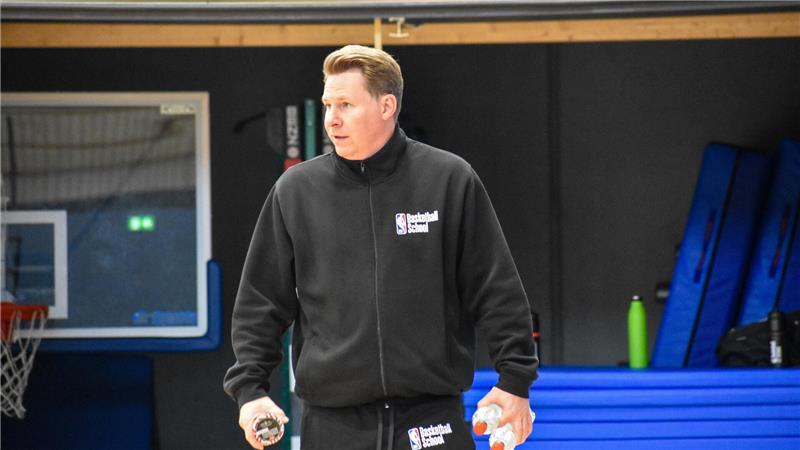 NBA-Camp in Stade: Junge Basketballer lernen von den Profis Andreas Wagner trägt Wasserflaschen in der Hand und hat eine schwarze Jacke an.