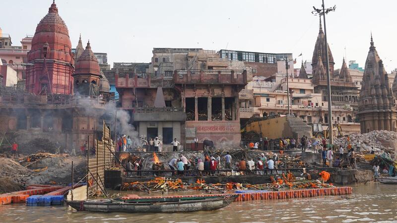 Angehörige schauen zu, wie Leichen auf Scheiterhaufen beim Ganges verbrennen.