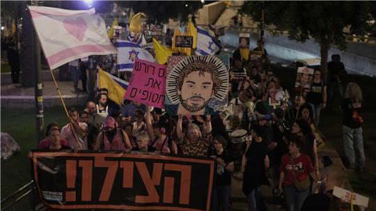 Angehörige und Unterstützer von israelischen Geiseln, die im Gazastreifen festgehalten werden, halten ein Transparent mit der Bitte um Hilfe in der Hand. Sie protestieren für die Freilassung der Geiseln aus der Gefangenschaft der Hamas und fordern ein Ende des Krieges.