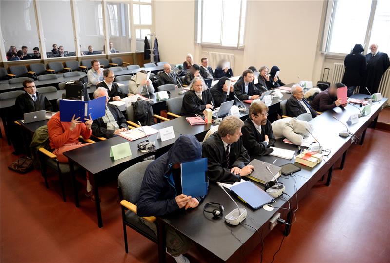 Angeklagte und Rechtsanwälte sitzen im Gerichtssaal. Foto Daniel Reinhardt/dpa