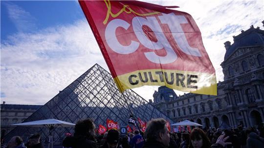 Angestellte zeigen eine Flagge der Gewerkschaft CGT vor dem Louvre, nachdem sie für einen Streik gestimmt haben.