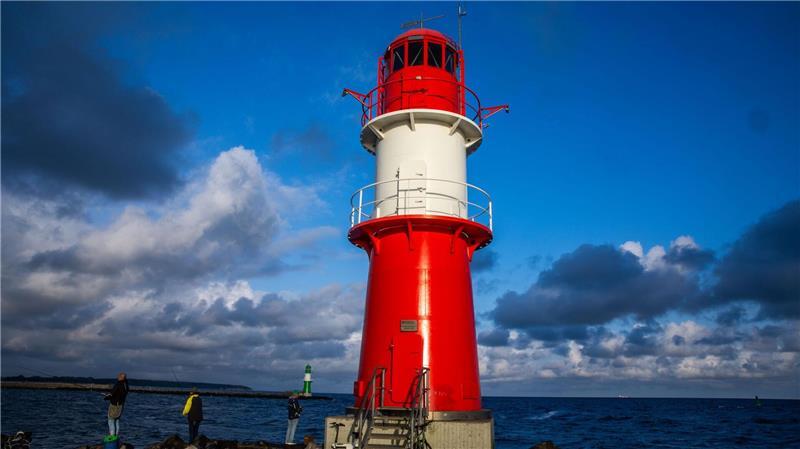 Bilder des Tages Angler stehen neben dem Leuchtfeuer auf der Ostmole an der Hafeneinfahrt in Warnemünde.