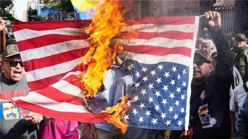 Anhänger der Regierung verbrennen eine US-Flagge in Caracas, nachdem US-Präsident Trump bekannt gegeben hatte, dass die US-Streitkräfte den venezolanischen Präsidenten Maduro und seine Frau gefangen genommen haben.