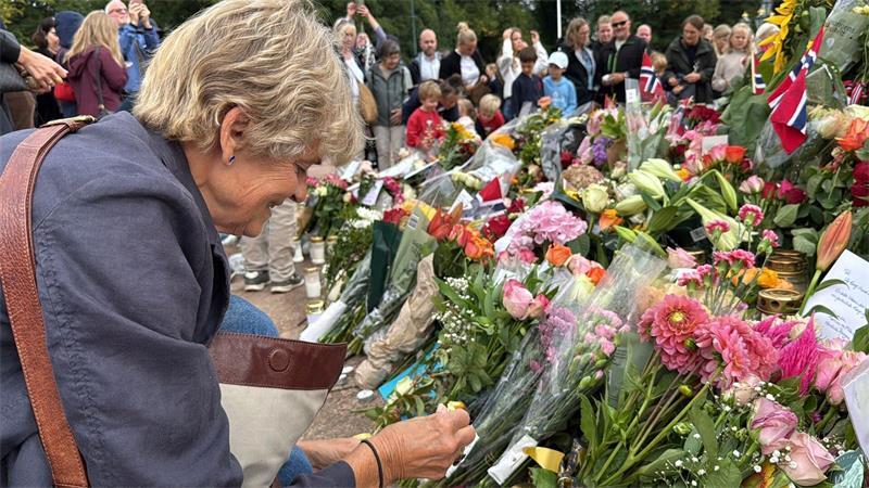 Anne Sandø Seierstad zündet eine Kerze für den gestorbenen Monarchen an. 