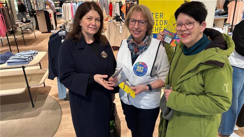 Annette Gutsfeld (Mitte), Mitgründerin Bündnis Buxtehude, spricht im Modehaus Stackmann mit den Kaufhaus-Besucherinnen Britta Pietzonka (links) und Erika Lefevre.