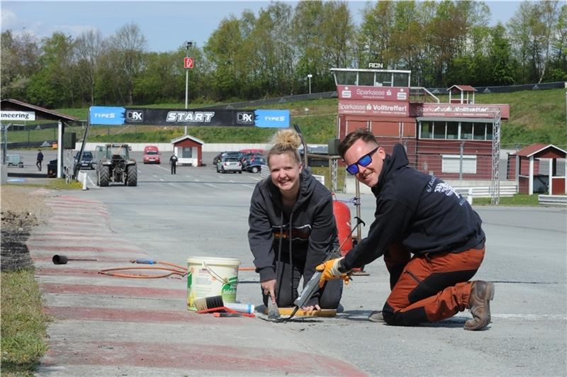 Annika Sandleben und Christopher Mercer dichten die Transponderschleife für die Zeitmessung ab. Fotos: Berlin