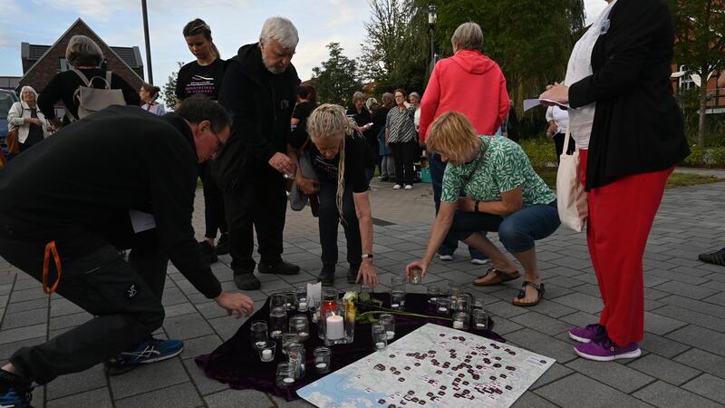Anteilnahme: Die Bürgerinnen und Bürger stellten Kerzen ab, rechts liegt eine Karte der Femizide in Deutschland - bis September 2023.