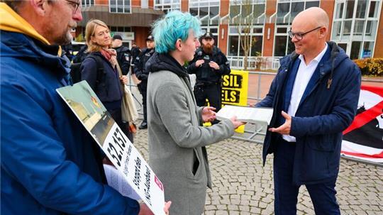 Anti-LNG-Aktivist Martin Lüdders aus Stade übergibt Unterschriften gegen Flüssigerdgas am Rande der Energieministerkonferenz.