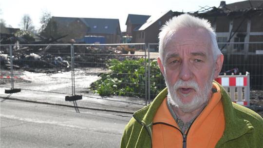 Anwohner Uwe Edeler informierte seine Nachbarn über das ausgebrochene Feuer. Im Hintergrund sind die Trümmer des Hofes zu sehen.