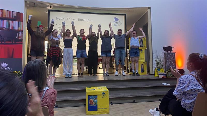 55. Buxtehuder Bulle: Spannende Auszählung und eine überglückliche Gewinnerin Applaus für ihre Performance: Acht Schülerinnen aus dem Theaterkurs des Jahrgangs 10 der IGS Buxtehude zeigten, wie ansteckend die Suche nach gutem Lesestoff sein kann.