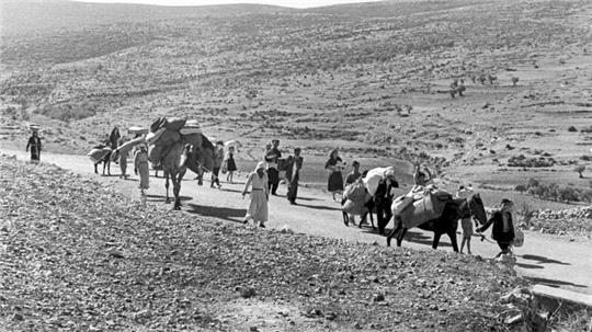 Arabische Flüchtlinge gehen mit ihren Kindern und Habseligkeiten im Gepäck am 9. November 1948 auf einer staubigen Straße von Jerusalem in den Libanon. Die Staatsgründung Israels war 1948 für Hunderttausende von Palästinensern mit Vertreibung und dem Verlust von Heimat verbunden.