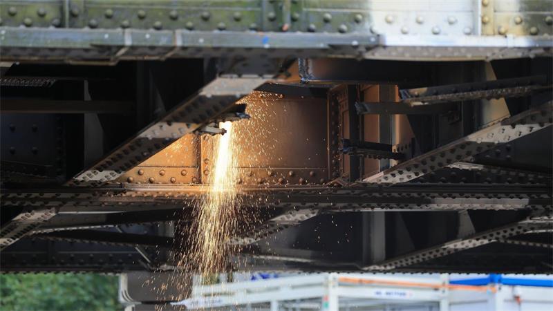 Arbeiter arbeiten daran, die alte Brücke zu zerteilen. 