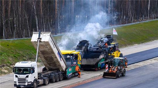 Arbeiter asphaltieren neue Abschnitte der Autobahn 14.
