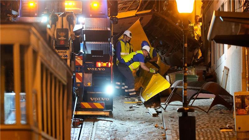 Bilder des Tages Arbeiter beseitigen die Trümmer einer entgleisten und verunglückten Standseilbahn in Lissabon.