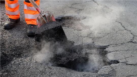 Arbeiter der Straßenmeistereien führen derzeit an vielen Stellen in ganz Deutschland Notreparaturen von Schlaglöchern durch. (Symbolbild)
