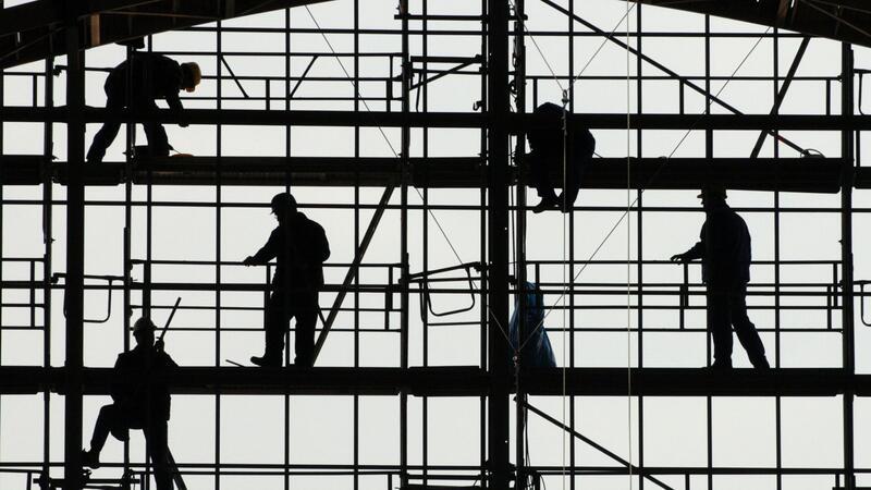 Ifo-Beschäftigungsbarometer sinkt Arbeiter montieren auf einem Gerüst die Glasfassade des Bahnhofs von Frankfurt am Main.