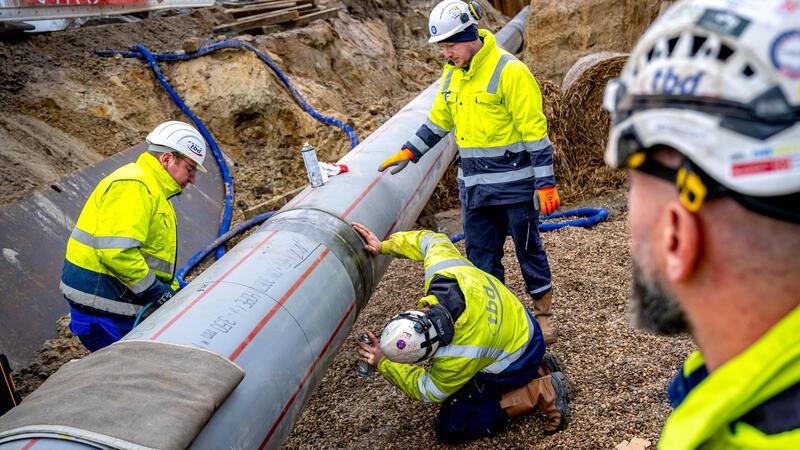 Arbeiter prüfen die letzte Schweißnaht einer weitere Anbindungspipeline für das LNG-Terminal in Wilhelmshaven.