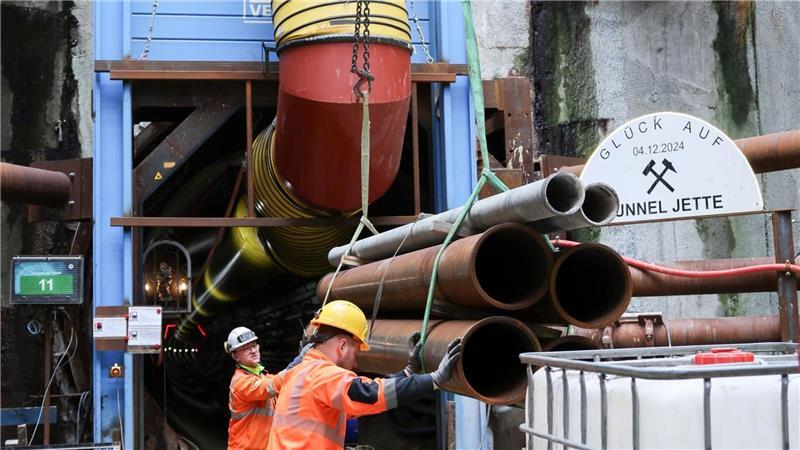 Arbeiter sind damit beschäftigt, Rohre auf einer Bahn zu positionieren. (Foto-Produktion)