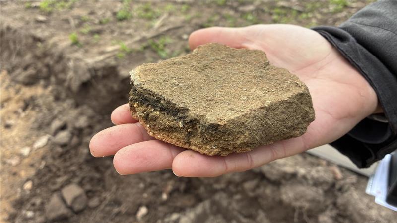 Archäologe Tobias Mörtz von der Uni Hamburg hält Keramik aus der Bronzezeit in seiner Hand.