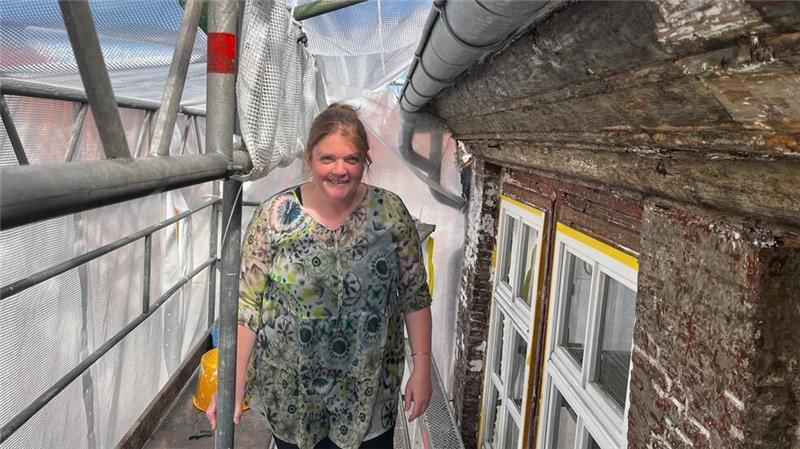 Architektin Angelika Buddelmann auf dem Baugerüst vor der Fassade.