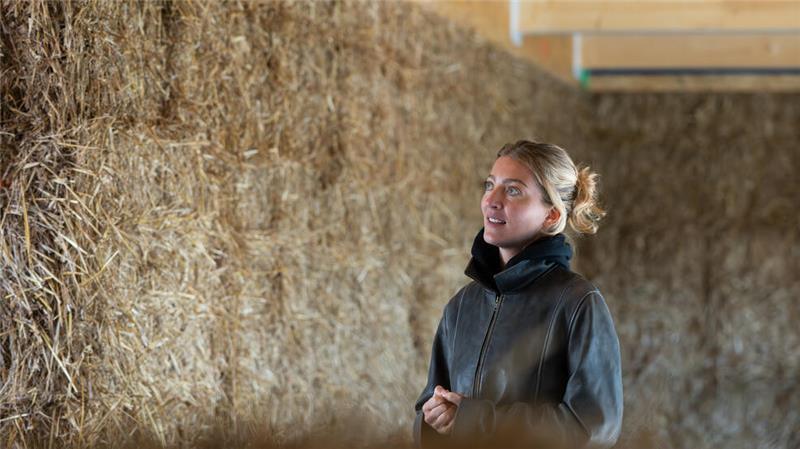 Nachhaltig Bauen mit Stroh: Wenn die Hauswände vom Feld nebenan kommen Architektin Anna Dienberg steht Im Rohbau des Dorfgemeinschaftshauses mit Wänden aus Stroh.
