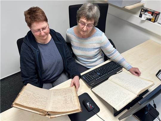 Archivarin Silke Ebers und ihre ehrenamtliche Mitarbeiterin Karin Hansen (rechts) präsentieren im Archiv der Samtgemeinde Lühe in Steinkirchen die alten Protokoll-Bände mit der ersten Erwähnung der politischen Gemeinde Grünendeich. Fotos: V