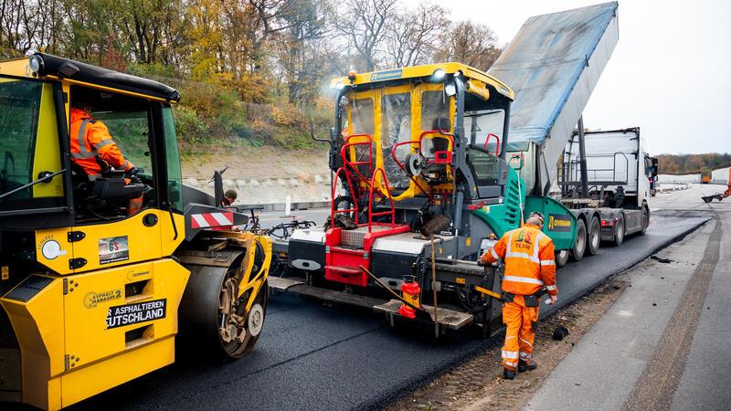 Asphalt wird auf der Autobahn A7 in Höhe des Volksparks auf die Straße aufgebracht. 