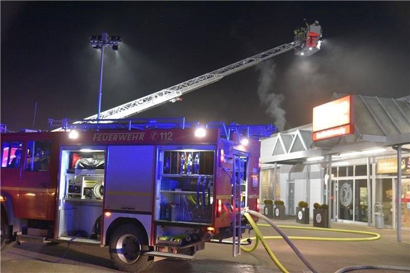 Auch von der Drehleiter aus kontrollieren Feuerwehrleute den Rewe-Markt in Drochtersen nach dem Brand. Fotos: Beneke