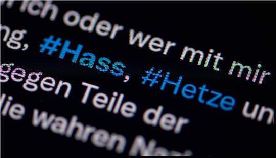 Auf dem Bildschirm eines Smartphones sieht man die Hashtags Hass und Hetze in einem Twitter-Post. Foto: Fabian Sommer/dpa