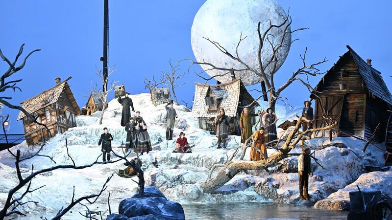 Bregenzer Festspiele zeigen Webers „Freischütz“ Auf dem Bodensee ist für die Inszenierung ein halb im Wasser versunkenes Dorf entstanden - mit schneebedeckten Hütten, kahlen Bäumen und einem riesigen Mond.