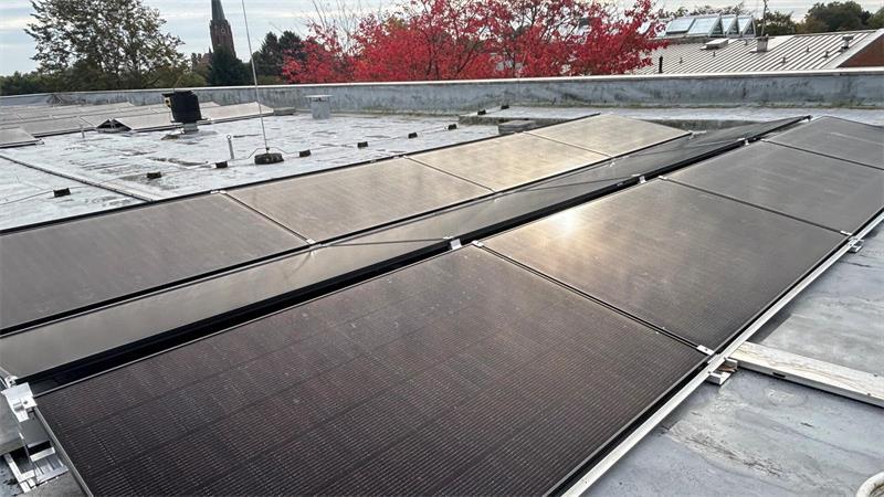 Auf dem Dach der Berufsbildenden Schulen Buxtehude ist die Energiewende sichtbar: Der Landkreis Stade als Schulträger lässt zurzeit Photovoltaikmodule zur Gewinnung von Strom aus Sonnenenergie installieren. Im Hintergrund ist der Turm der St.-Petri-Kirche zu sehen.