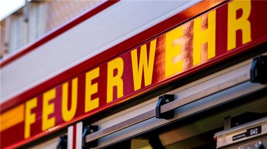 Auf dem Einsatzfahrzeug ist in gelber Farbe der Schriftzug „Feuerwehr“ zu lesen.
