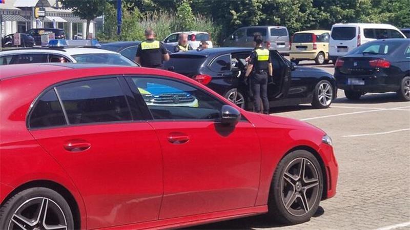 Vor Supermarkt: Hier sorgen Spendensammler für einen Polizeieinsatz Auf dem Parkplatz werden die beiden Spendensammler an ihrem Fahrzeug überprüft.