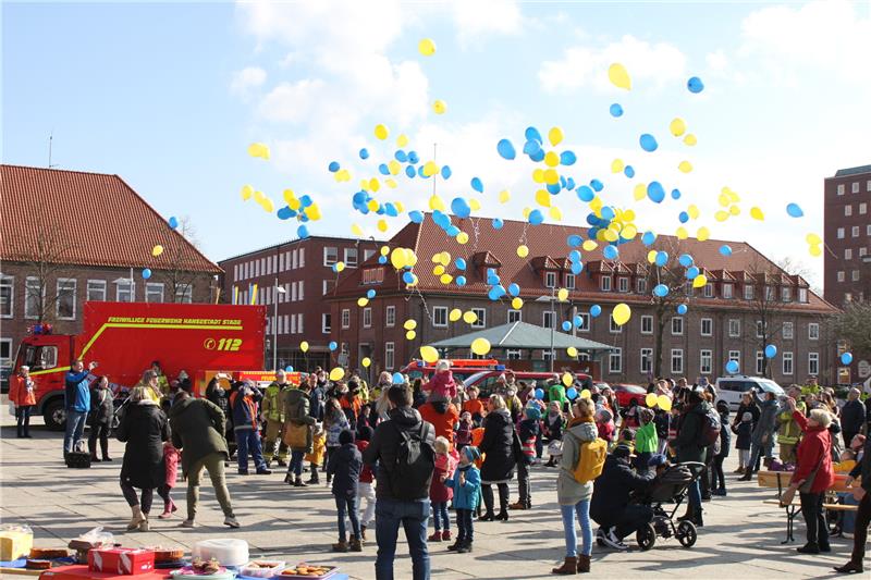 Auf dem Platz Am Sande in Stade steigen am Sonnabend blau-gelbe Luftballons als Zeichen der Solidarität mit der Ukraine in den Himmel. Foto: Feuerwehr