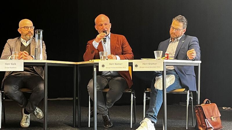 Auf dem Podium (von links): Stadtrat Lars Kolk, SPD-Bürgermeisterkandidat Kai Koeser und CDU-Bürgermeisterkandidat Arne Kramer.