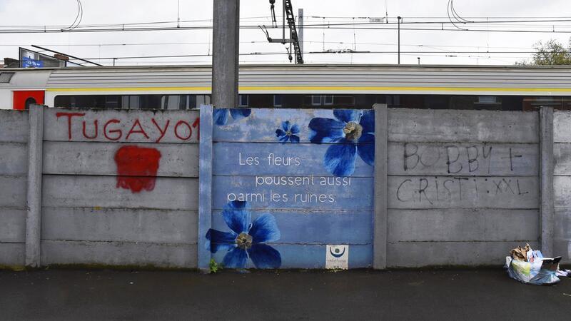 Belgiens Trauma: Mädchenmörder vor 20 Jahren verurteilt Auf dem Wandbild steht auf Französisch: „Auch zwischen den Ruinen wachsen Blumen.“