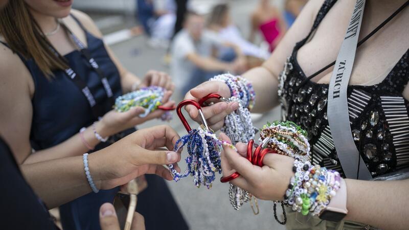 Glitzern in der Sonne: Fans warten auf Taylor Swift Auf den Armbändern verewigen die Fans Zitate der Musikerin.