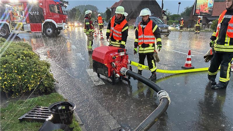 Auf der B73 in Hedendorf behindert am Dienstagabend Starkregen den Verkehr. Feuerwehrleute pumpen das Wasser von der Fahrbahn ab.