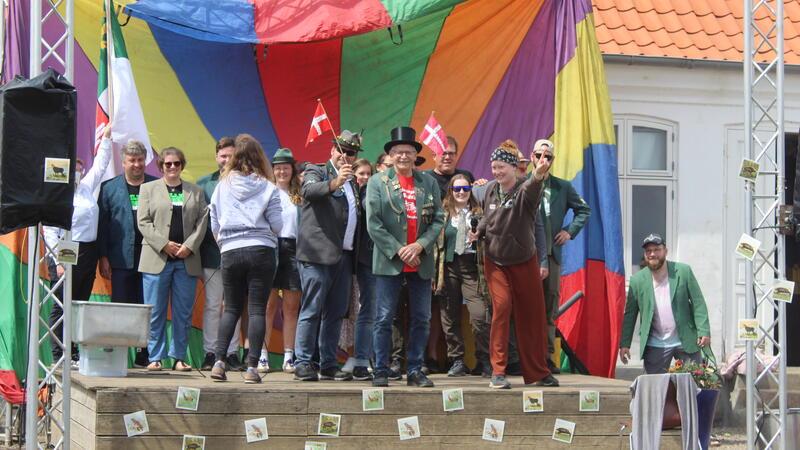 Auf der Bühne vor der Taufe: Patin Lea ehrt Werner Schröter für 25 Jahre Engagement im Zeltlager Lille Bodskov - und alle feiern mit.