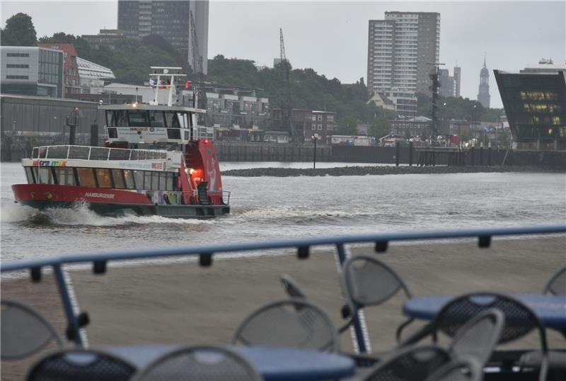 24-Stunden-Reportage: Mit der Elbfähre in die City Auf der Fähre nähern sich die Pendler aus Finkenwerder allmählich der Hamburger Innenstadt . Auch in die Gegenrichtung ist ein Linienschiff um 5.15 Uhr gestartet (links im Bild). Auf Höhe des Altonaer Fischmarktes ist neben dem Dockland-Geb