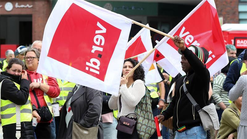 Hunderte Beschäftigte im Handel protestieren für mehr Geld Auf der Kundgebung werden Verdi-Flaggen geschwenkt.