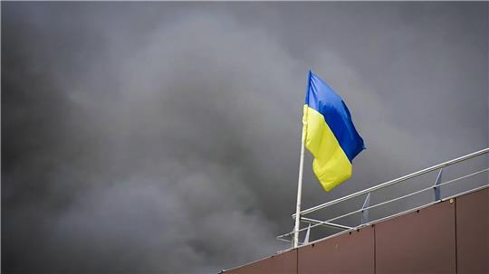 Auf diesem von der Regionalverwaltung Dnipropetrowsk veröffentlichten Foto weht die ukrainische Flagge, während nach einem russischen Raketenangriff Rauch aufsteigt.