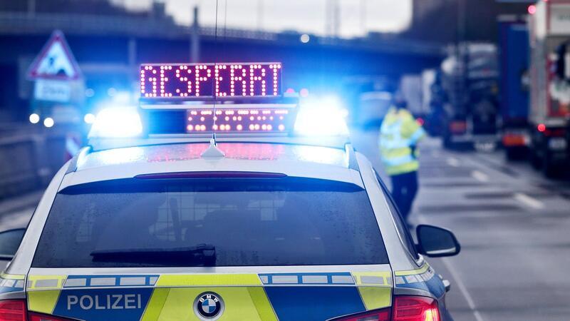 Auf einem Polizeifahrzeug leuchtet die Aufschrift „Gesperrt“.