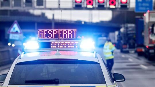 Auf einem Polizeifahrzeug leuchtet die Aufschrift „Gesperrt“.
