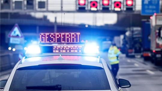 Auf einem Polizeifahrzeug leuchtet die Aufschrift „Gesperrt“.