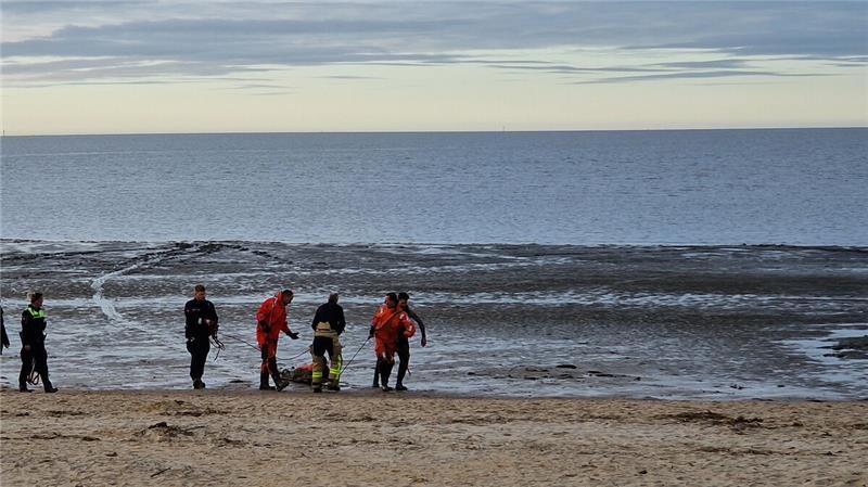 Frau vorm Ertrinken gerettet: Er ist der Cuxhavener Held aus dem Watt Auf einem Rettungsbrett wird die Frau aus dem Watt gezogen. Foto: Feuerwehr