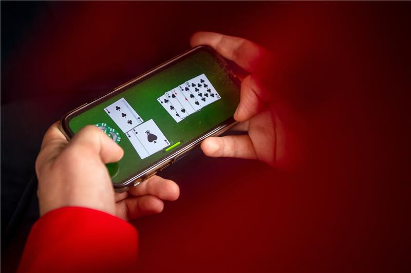 Auf einem Smartphone wird ein Online-Casinospiel gespielt. Mit dem neuen Glücksspielstaatsvertrag, der am 1. Juli in Kraft trat, werden bisher verbotene virtuelle Automatenspiele im Internet sowie Online-Casinos mit Poker oder Roulette erlaubt. Foto: Sina Schuldt/dpa